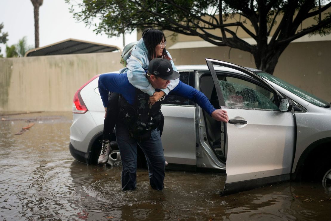 detection. Bryce Ford of the Santa Barbara Police Department helps a motorist get out of his car on a flooded street during heavy rains.