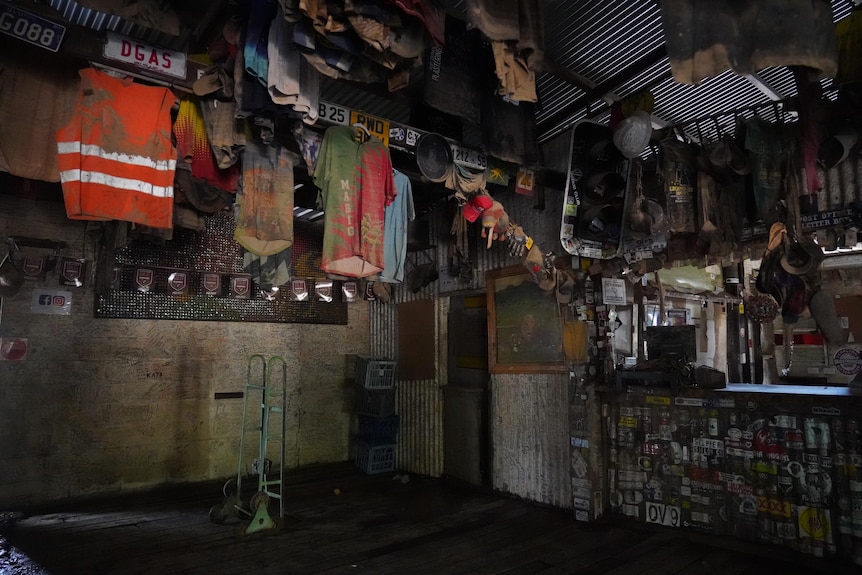 A collection of mud-stained shirts and other memorabilia hang on the wall next to the mud bar.