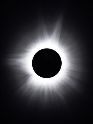 The black circle in the center is the sun covered by the moon, surrounded by a huge white halo, which is the corona, the sun's outer atmosphere.