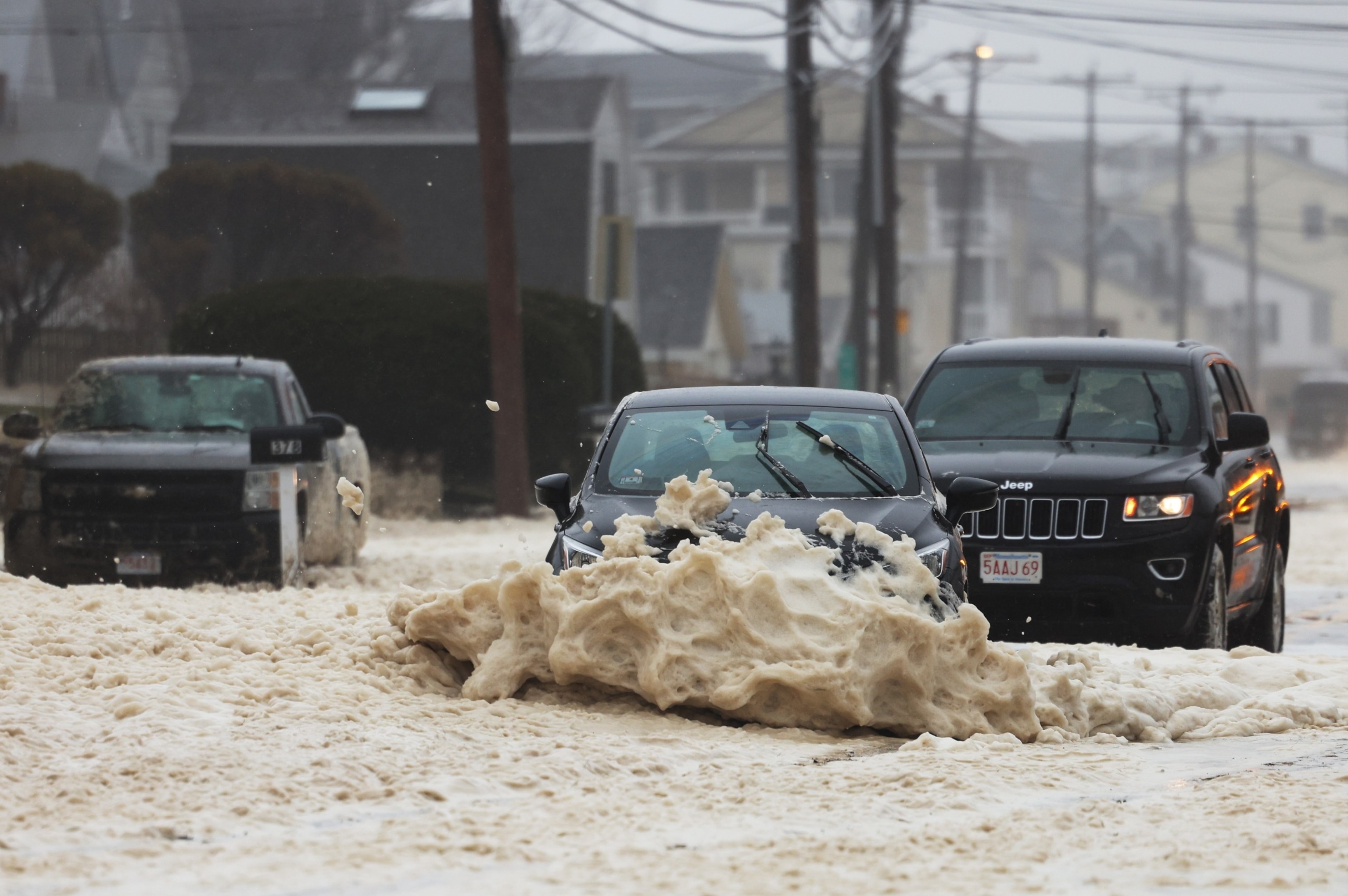 Photo: A car drives through a flooded street during Nor'easter on April 4, 2024, in Salisbury, Massachusetts.