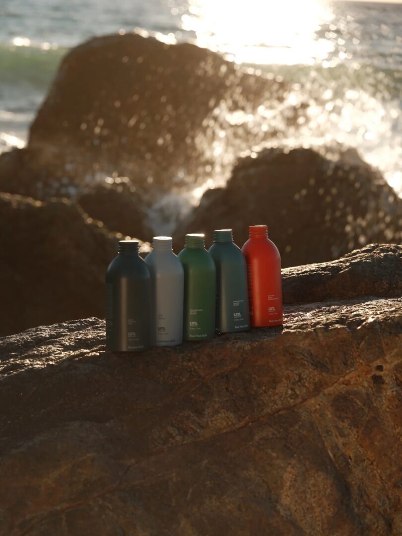 University.Refillable body care system displayed on beach rocks