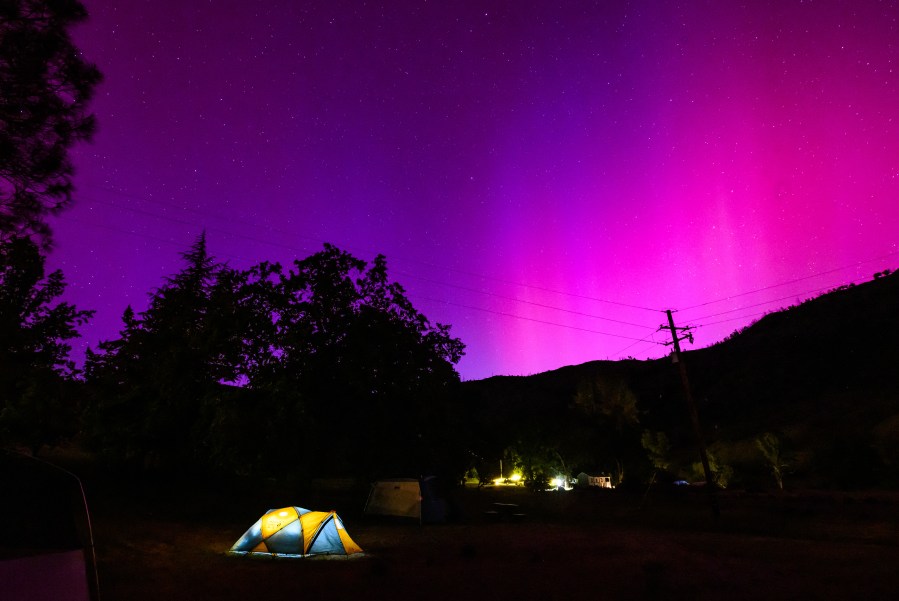 The Aurora Borealis, or Aurora Borealis, lights up the night sky above campers' tents north of San Francisco on May 11, 2024 in Middletown, California. A spectacular skylight show has hit the UK - and threatens satellites and power grids with possible disruption as the situation continues into the weekend.  (Photo by Josh Edelson/AFP) (Photo by Josh Edelson/AFP via Getty Images)