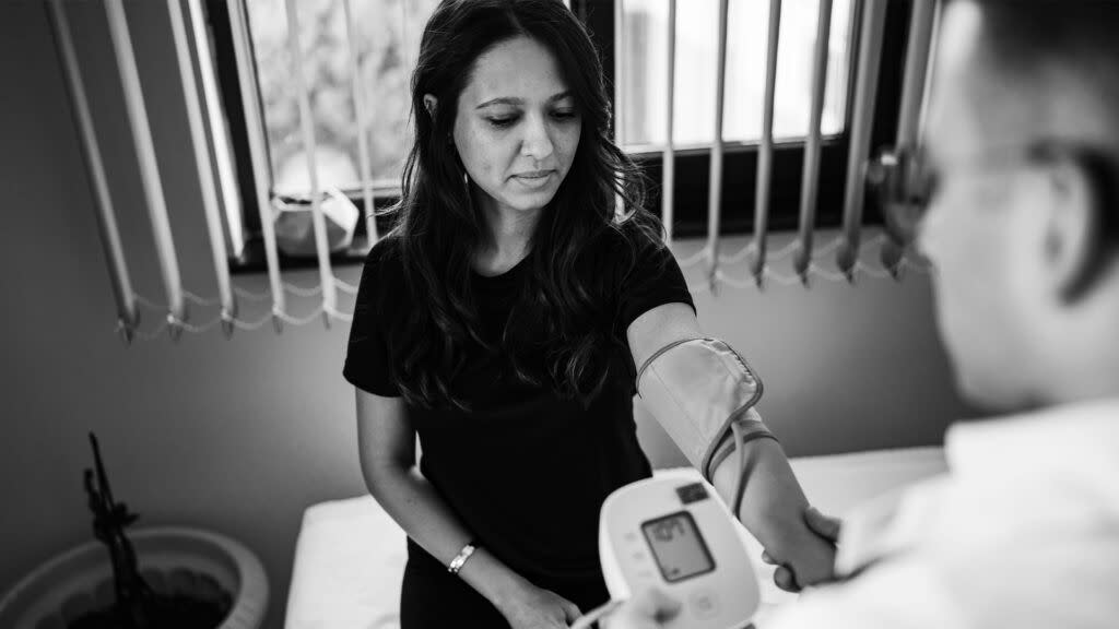 A doctor checks a woman's blood pressure