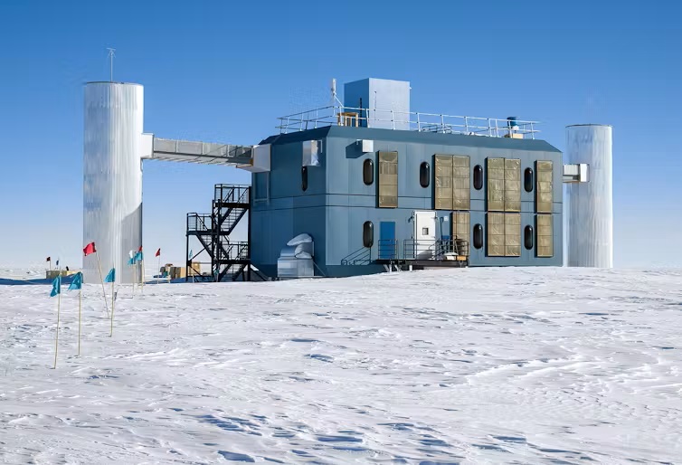 Rare neutrinos: A 2-story building with an attached silo on either end with snow.